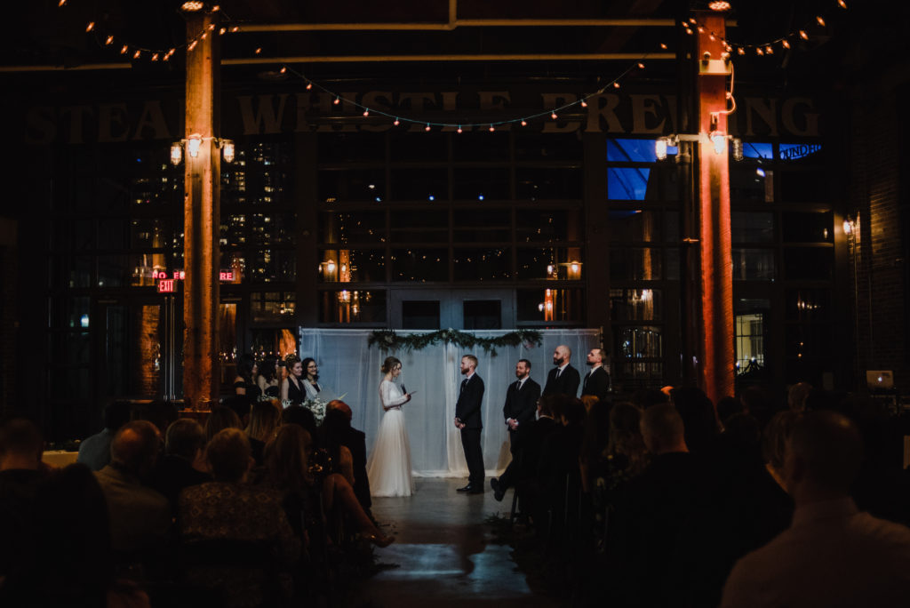 bride reading her vows during their wedding ceremony in toronto at steam whistle brewery