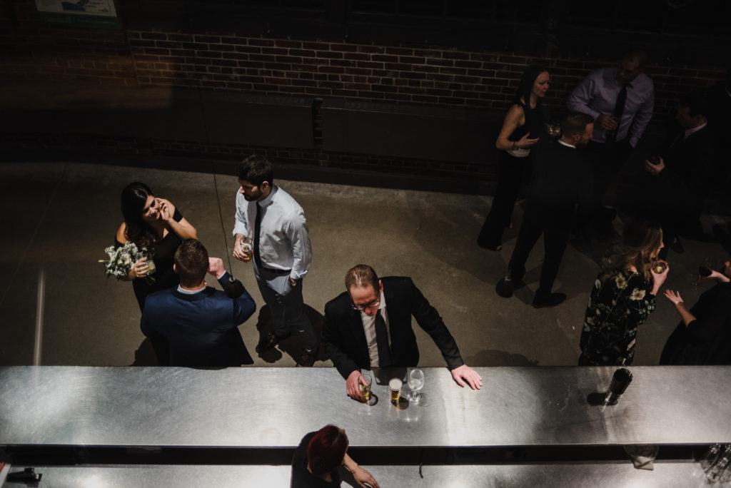 photo from above of father of the bride ordering a drink from the bar during cocktail hour at the toronto wedding