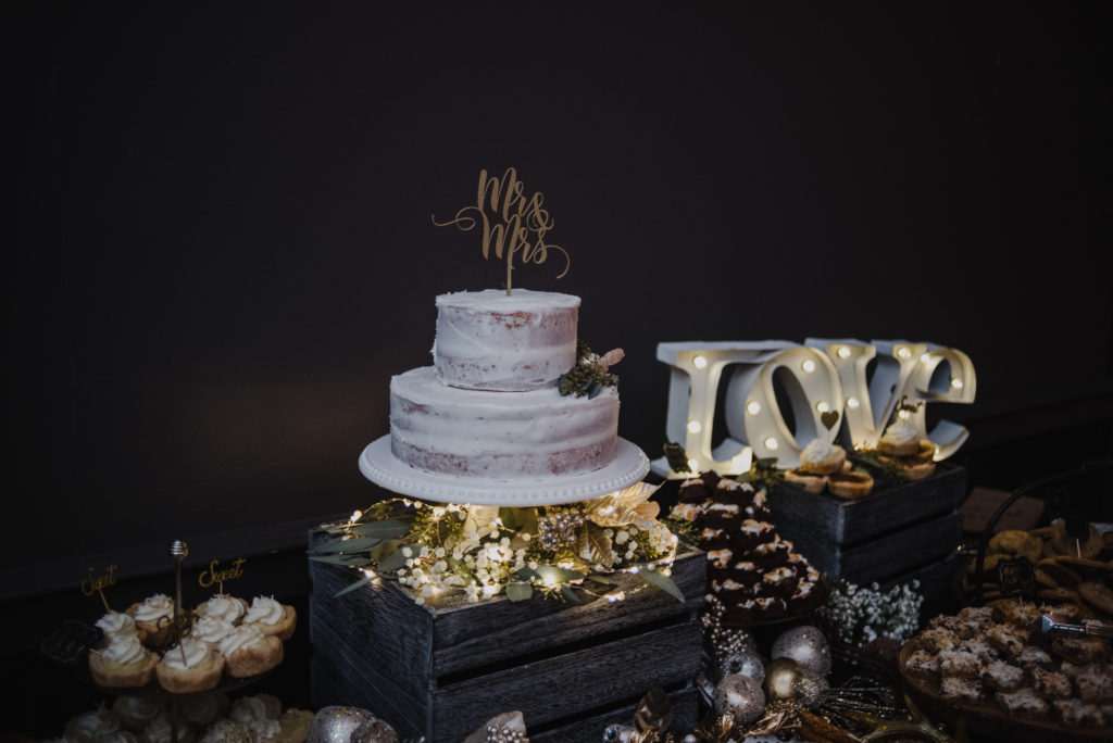 wedding cake with assorted desserts around it 