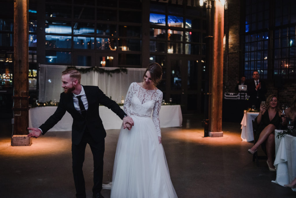 groom is doing a 'bowing' gesture to guests after he finished his first dance with his new wife