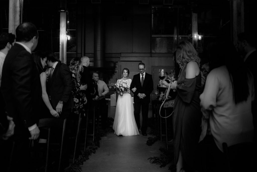 bride and her father walking down the aisle during the wedding ceremony in toronto